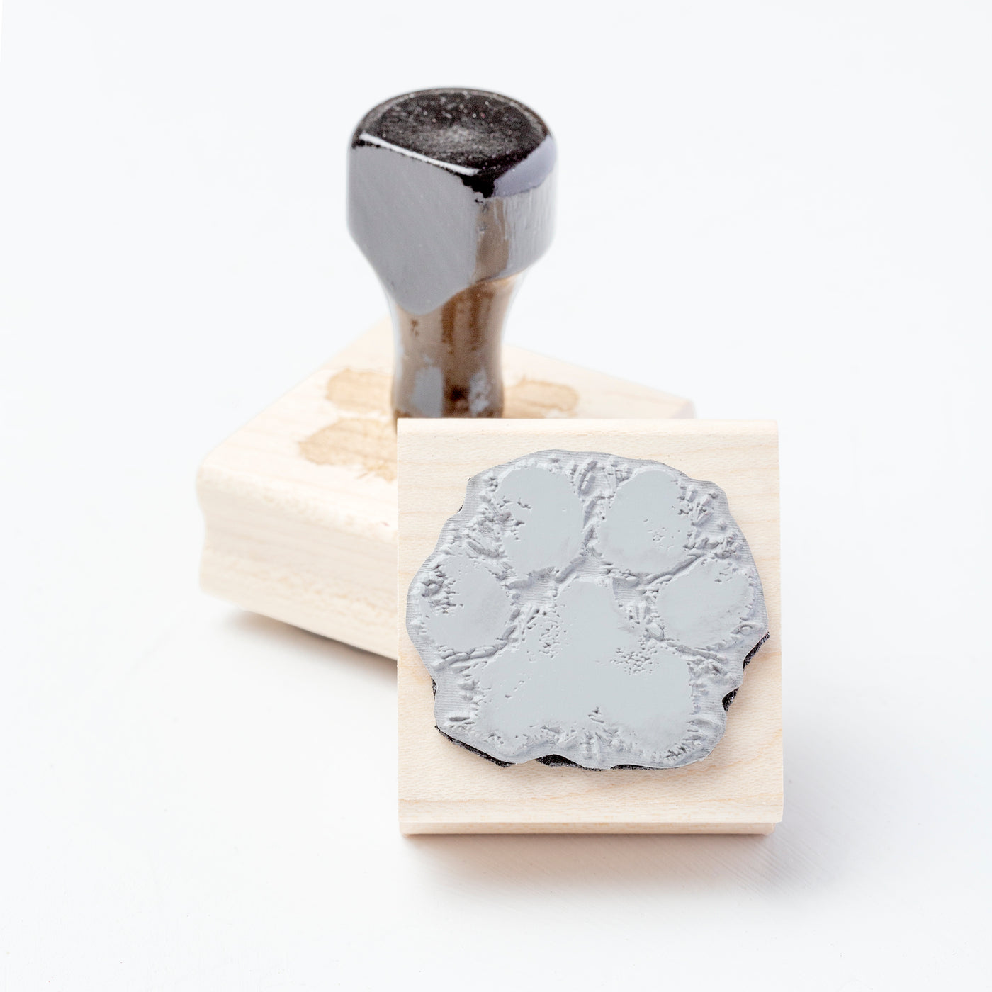 Underside of wooden rubber stamp with cat paw print