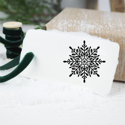 White gift tag stamped with Christmas snowflake and tied with velvet green ribbon | Heirloom Seals