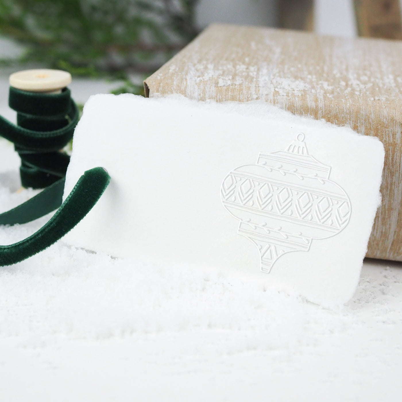 White gift tag embossed with vintage inspired bauble and tied with velvet green ribbon | Heirloom Seals